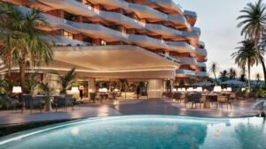Vestíbulo abierto junto a una piscina y fachada ondulada