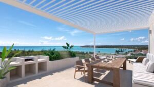 Pérgola blanca sobre terraza con vistas al mar